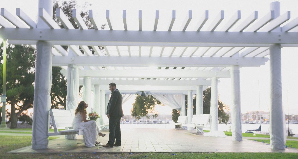 A photographer capturing a bride and groom under a pergola in Los Angeles.