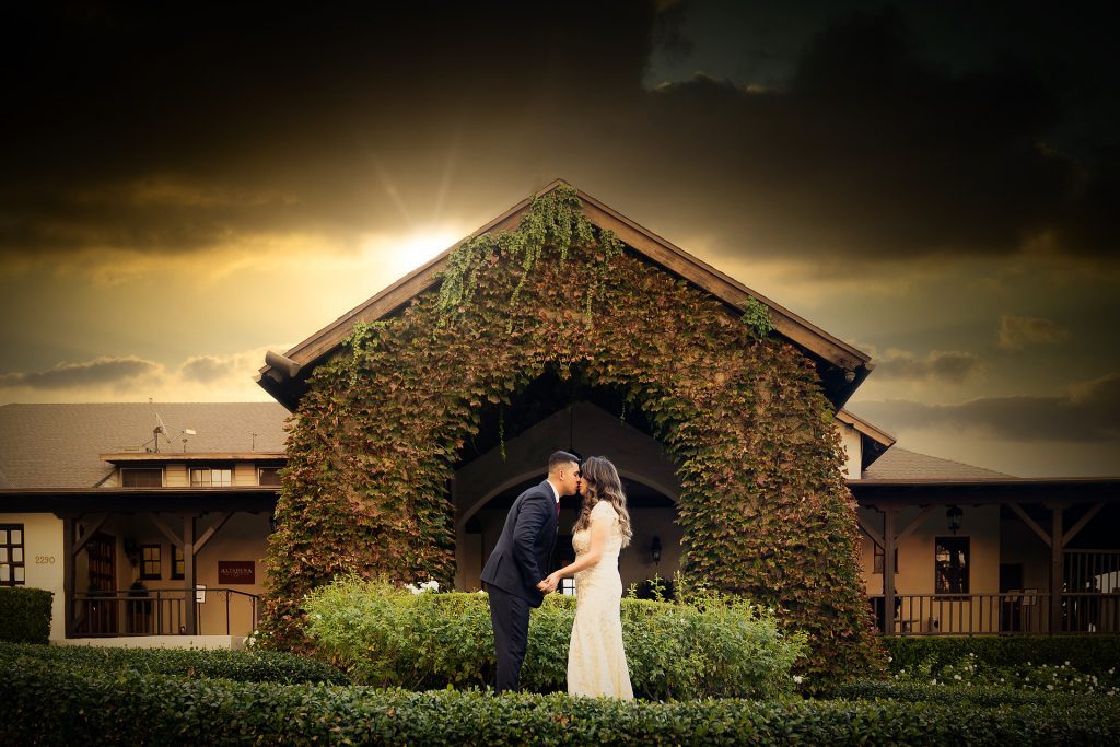 A wedding photographer captures a bride and groom in front of a building in Los Angeles.