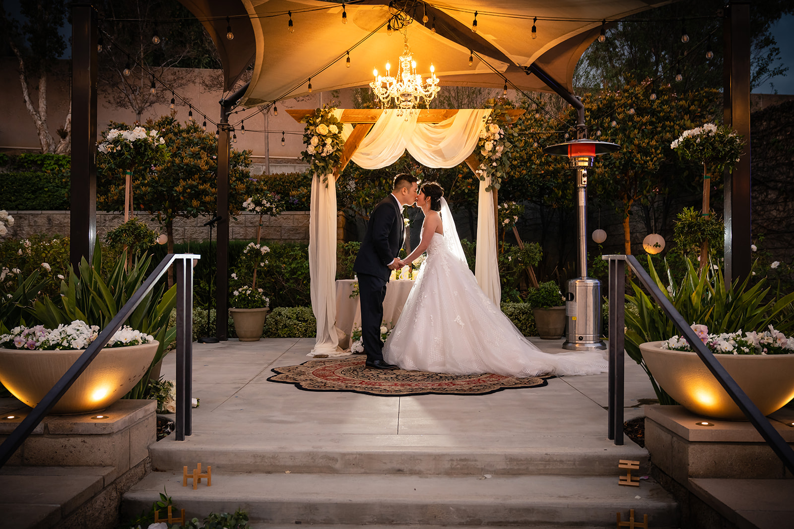 Photographer Thomas Kim captures a beautiful outdoor wedding ceremony in Los Angeles, featuring a bride and groom kissing.