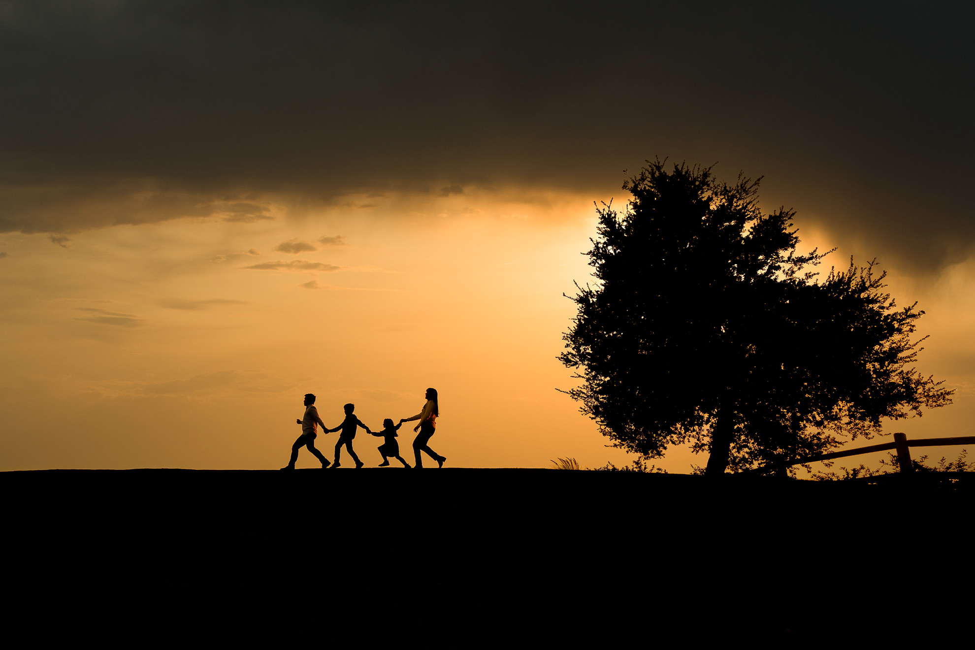 ThomasKim_photography Silhouette of a family walking ABOUT on a hill.