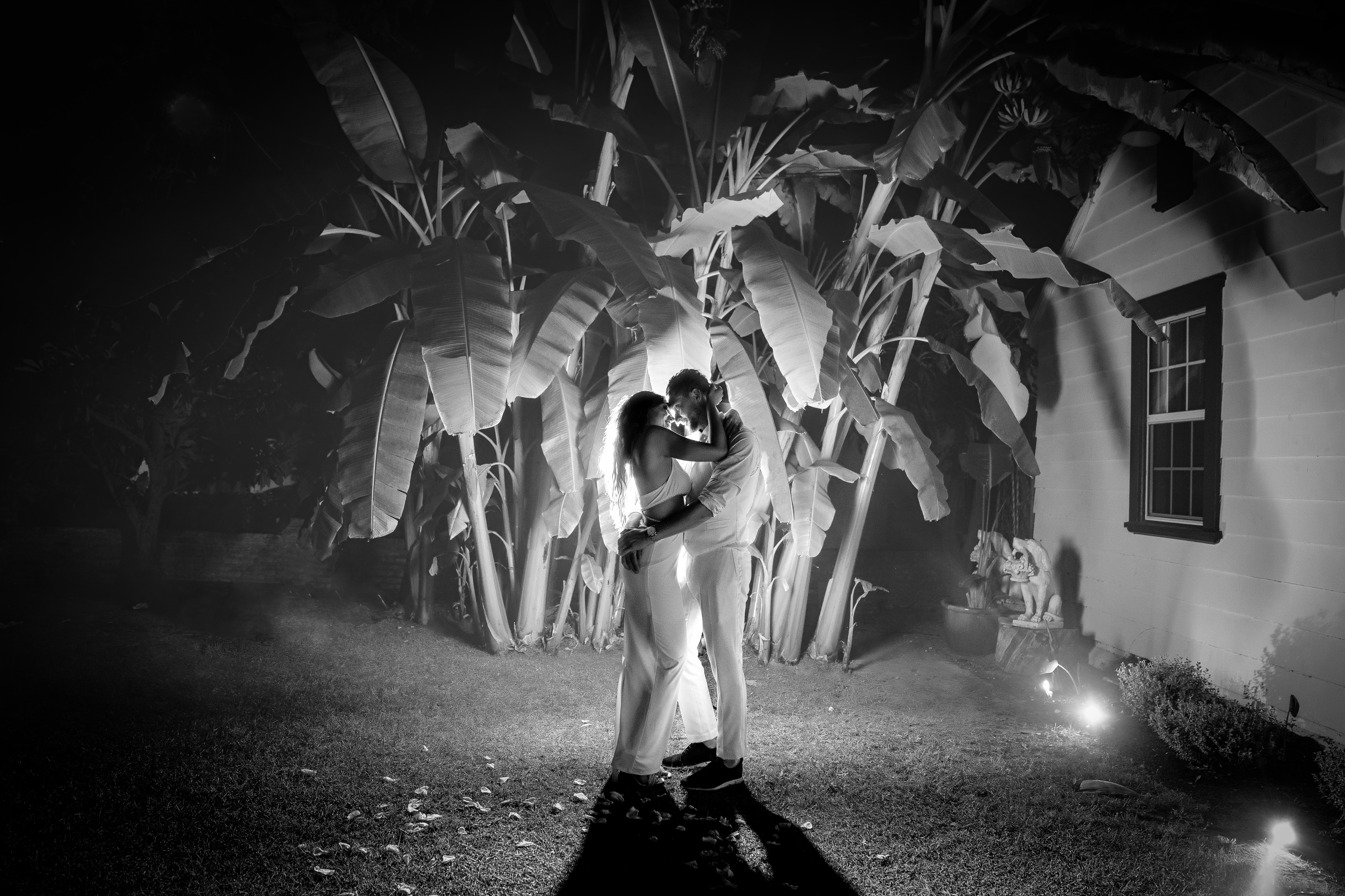 ThomasKim_photography A black and white photo of a bride and groom in front of a tree with initials V & J.