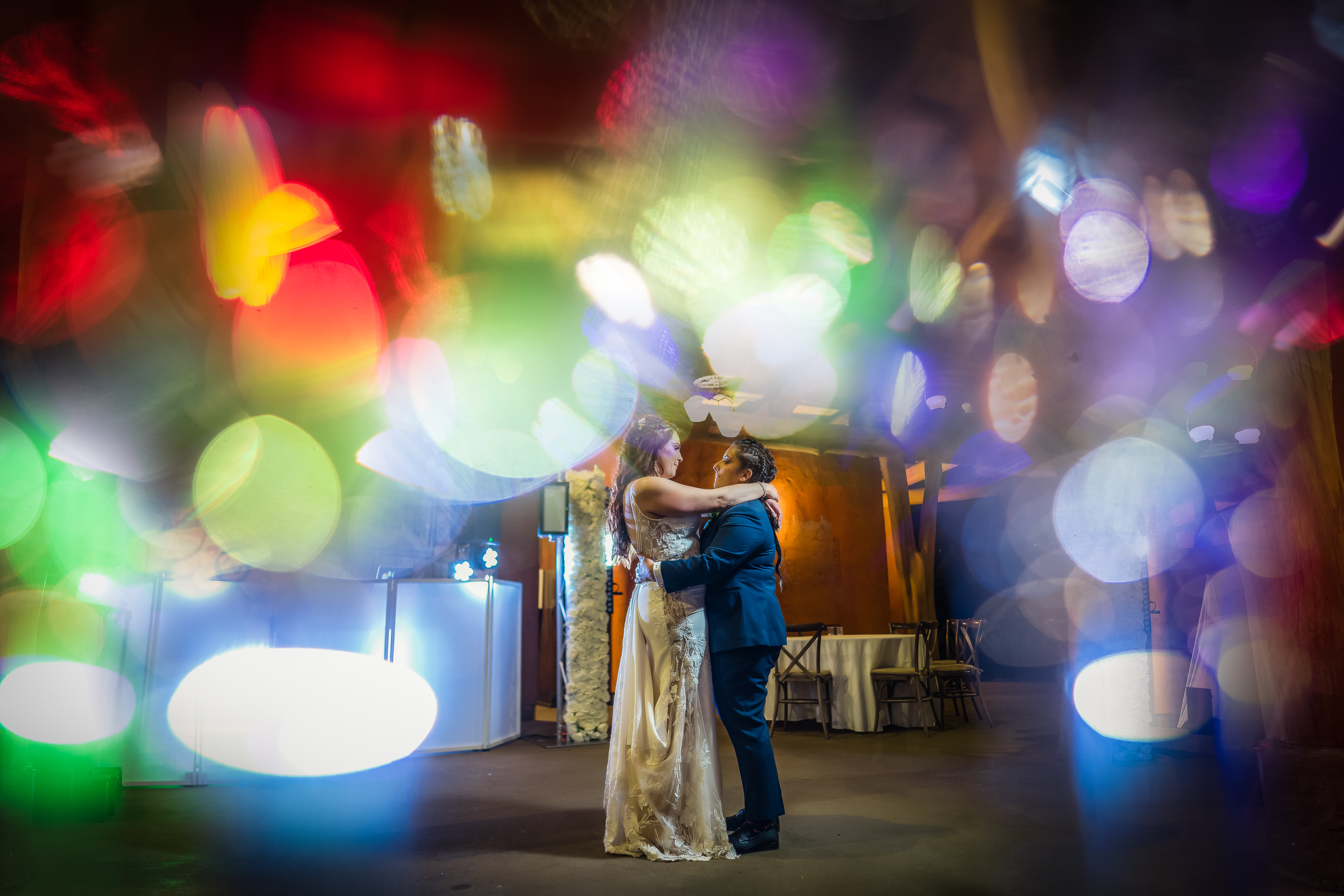 ThomasKim_photography A bride and groom dance in front of colorful lights at their wedding (Bride & Groom, Colorful Lights).