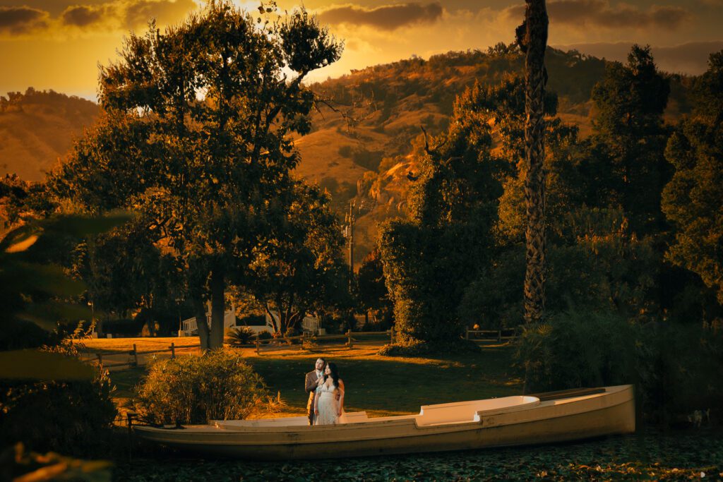 ThomasKim_photography A Los Angeles wedding photographer captures a bride and groom standing in front of a boat at sunset.