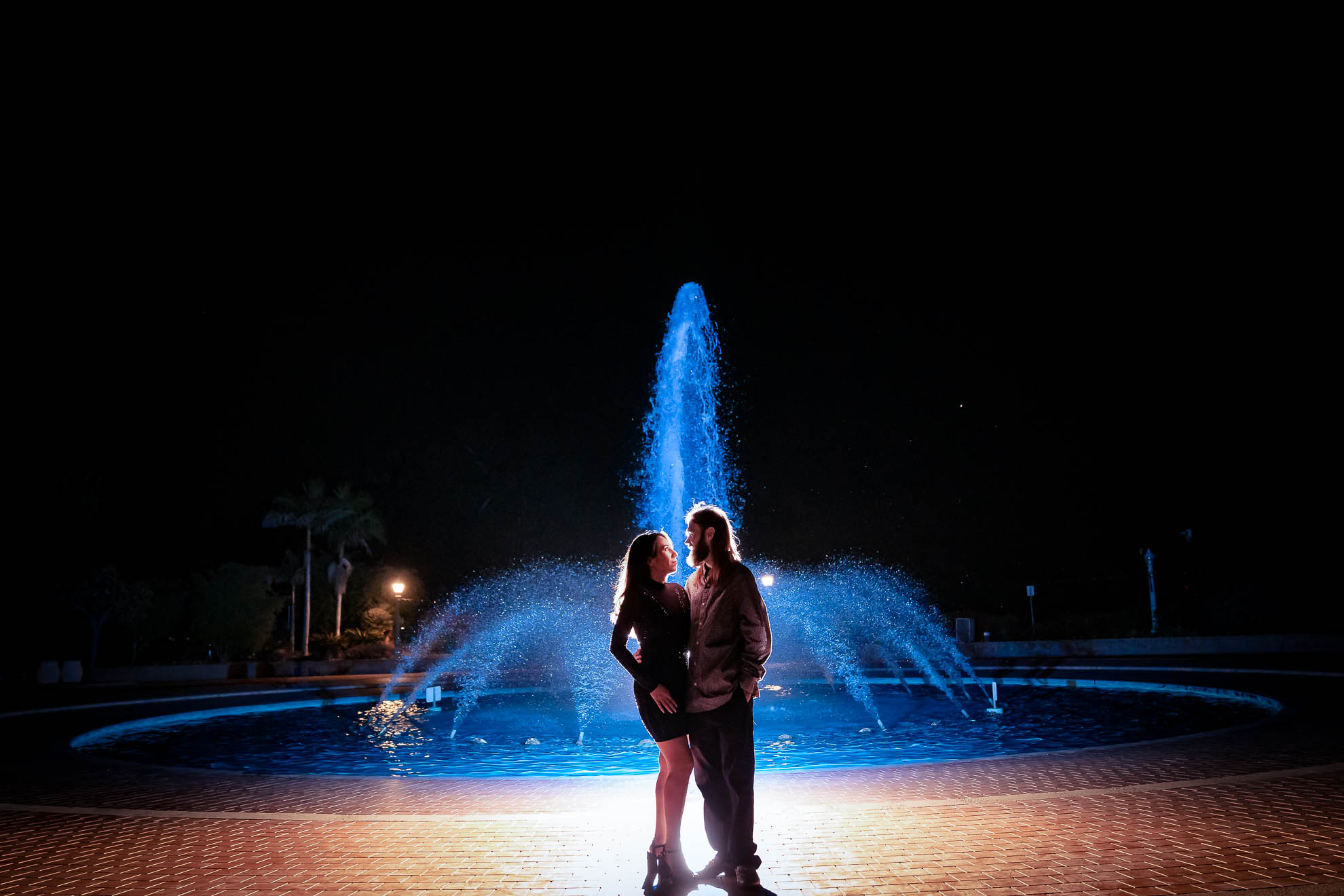 ThomasKim_photography A couple standing in front of a fountain in San Diego's Balboa Park at night.