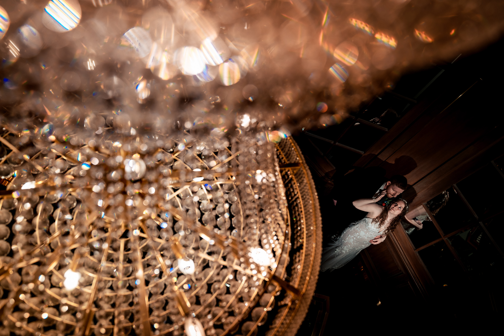 ThomasKim_photography J & M Copy, a bride and groom standing under a chandelier.