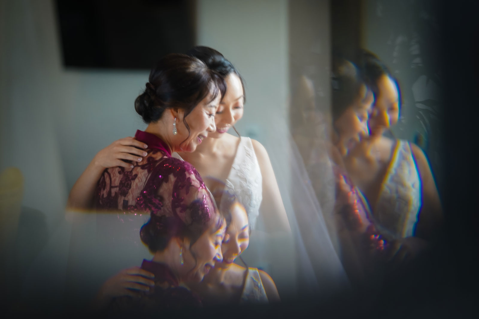 ThomasKim Photography Los Angeles Wedding Photographer Two multicultural brides hugging each other in front of a mirror, celebrating diversity in Los Angeles.