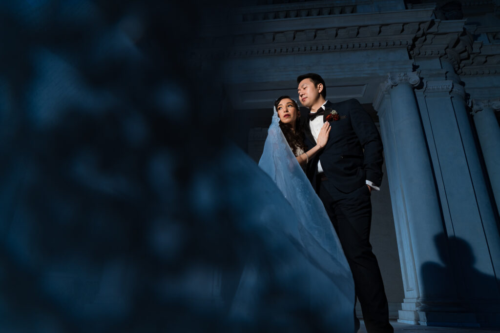 ThomasKim_photography Y& A posing in front of a building on their wedding day.