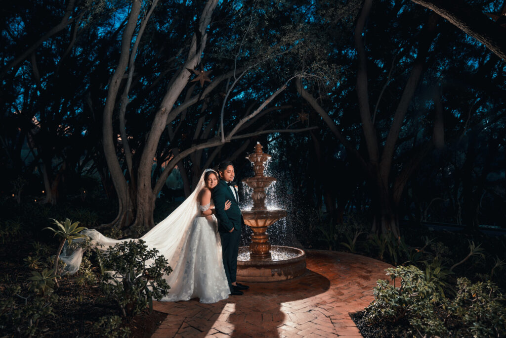ThomasKim Photography Los Angeles Wedding Photographer Los Angeles Wedding Photographer capturing a bride and groom standing in front of a fountain at night.