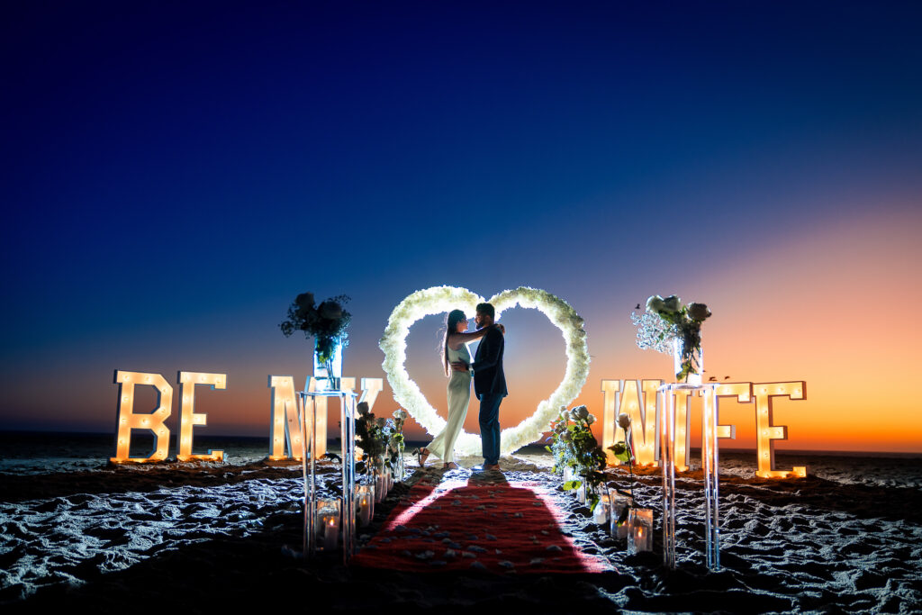 Couple holding hands against Malibu sunset