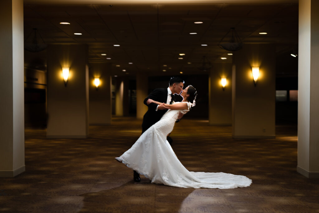 A bride and groom kissing in a dark hallway
